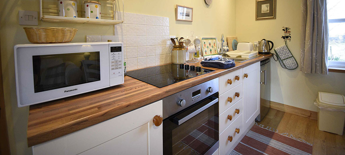 Half of Three self catering accommodation contains a modern kitchen with oven hob and fridge freezer