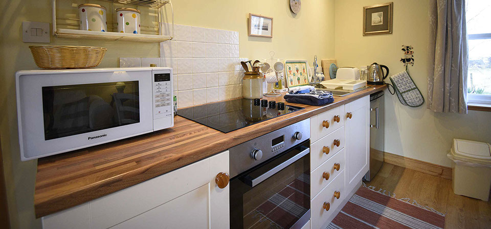 Half of Three self catering accommodation contains a modern kitchen with oven hob and fridge freezer